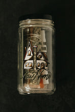 Load image into Gallery viewer, A clear glass jar with a black lid, containing a sage bundle, cinnamon stick, selenite wand, salt, soy taper candle, printed with a house illustration and the words 'BLESSING FOR YOUR NEW HOME.' The jar is photographed from above on a dark, textured background.
