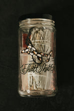 Load image into Gallery viewer, A clear glass jar with a black lid, containing a sage bundle, cord, and other items, photographed against a dark textured background. The jar has a printed graphic of a broken chain, and the words "Let That Shit Go."

